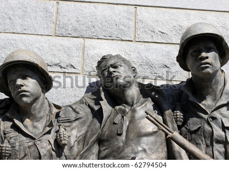 Statue of two soldiers helping an injured soldier emphasis on faces.