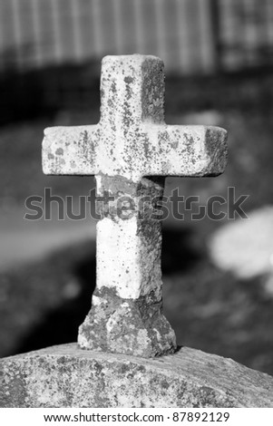 Latin cross on tombstone in black and white.