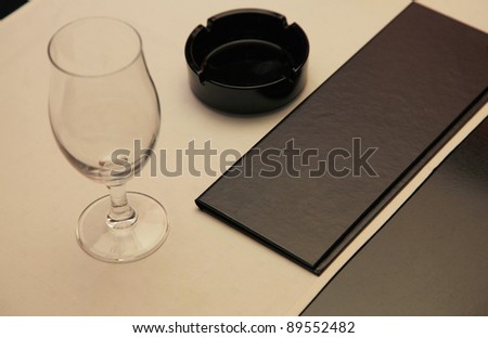 empty wine glasses, ashtray and menu on the table