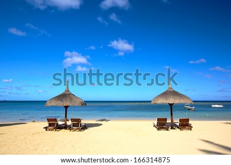 Tropical beach with lounge chairs and umbrella in Mauritius