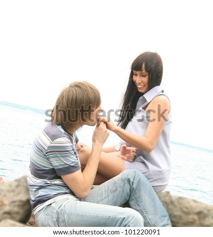 A gorgeous couple roaming at the sea shore  the guy kisses the girl\'s hand and makes a proposal on the romantic stone ocean
