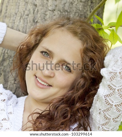 young blue-eyed smiling woman in white against blurred forest background with selective focus and copy space Beautiful girl in the fairy forest