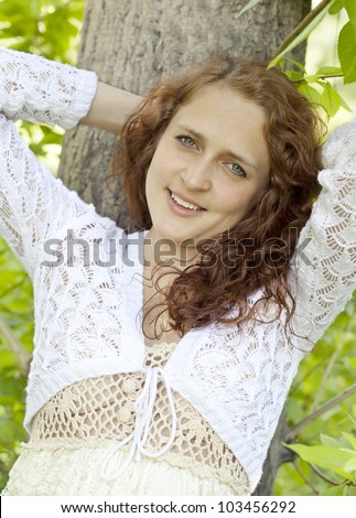 young blue-eyed smiling woman in white against blurred forest background with selective focus and copy space Beautiful girl in the fairy forest