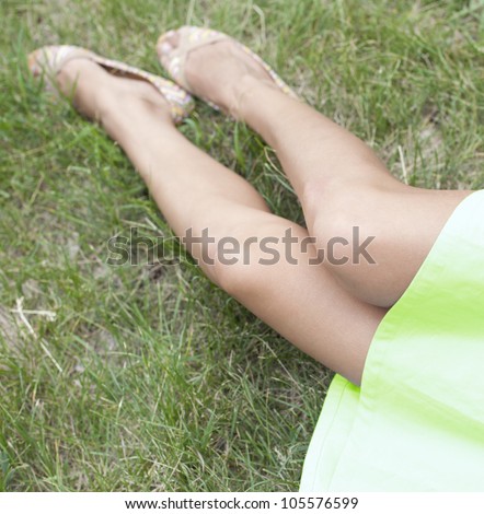 slender legs young girl on green grass