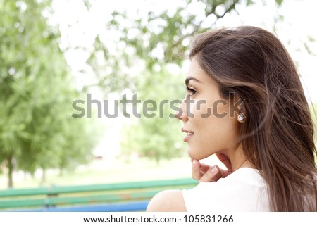 dreaming attractive young white girl posing outdoors in a bright sunny summer day