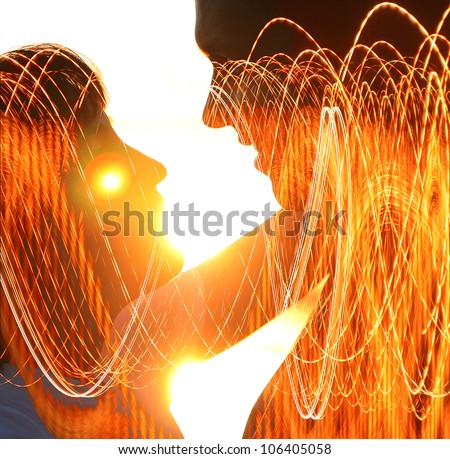 Young couple silhouette hugging and looking at each other outdoors at night neon city background
