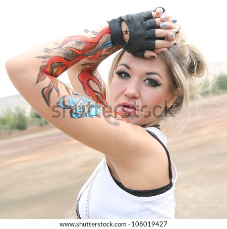 woman painted body art in the form of fire in the white t-shirt  on the background of desert