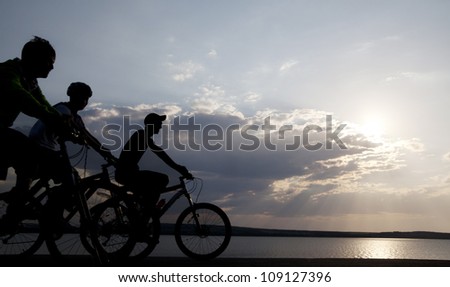 Image of sporty three bicycles outdoors against sunset. Silhouette. space for inscriptions