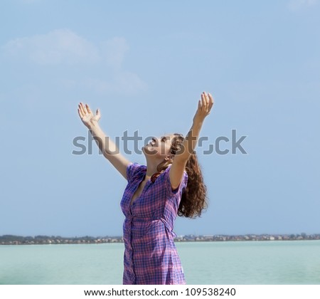 beautiful young woman opened her hands with delight at the blue sky - Girl embraces the whole world