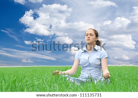 girl meditates in green grass background