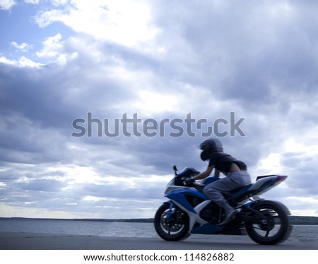 blurred motorcyclist against blue sunset