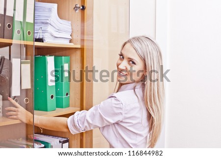 portrait of a girl on the background of the cabinet with shelves with files
