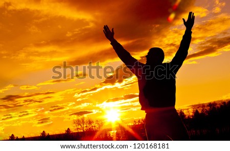 Meeting of the sun. The man on with the hands lifted above, on a background of a sunset