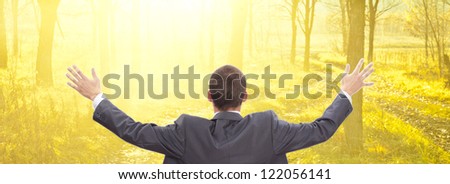 Man with raised hands sitting on chair on orange  sunny sunset Skies Colorful autumn Fantasy