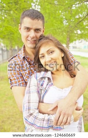 Hispanic latin Portrait of a beautiful young happy smiling couple - walking at green park outdoor on green background