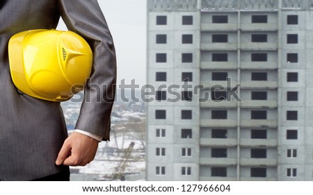 engineer yellow helmet for workers security on the background of a new high-rise apartment buildings of gray