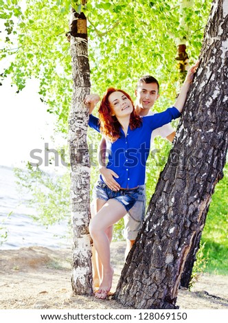 beautiful young couple embracing outdoors in the forest, true love and passion