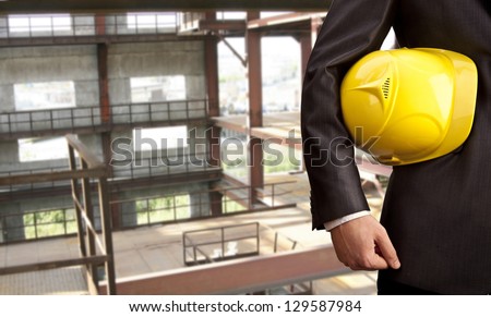 engineer yellow helmet for workers security on the background of a new high-rise apartment buildings of gray