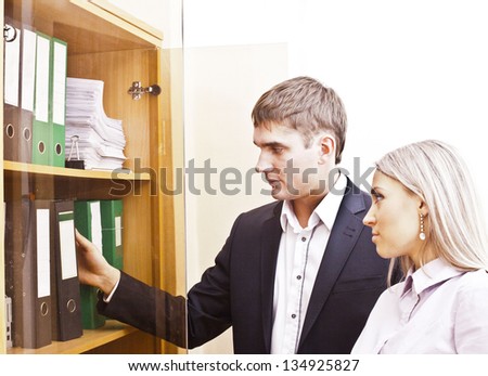 business colleagues together looking for documents in a case of folders