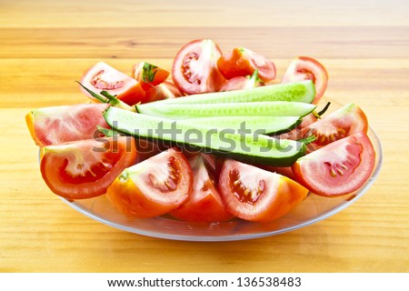 Simple salad in transnparent plate on wooden natural table