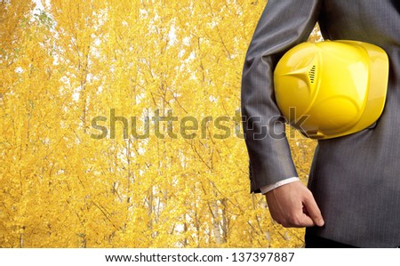 engineer yellow helmet for workers security over yellow autumn forest