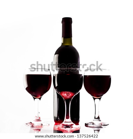Elegant red wine glass and a wine bottle isolated on white background