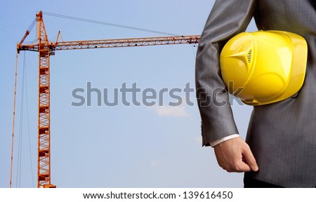 engineer yellow helmet for workers security over building crane background