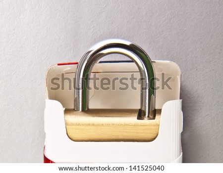 Pack of cigarettes on the lock  on gray background  the idea of of laws banning smoking in public places, about the dangers of passive smoking, the concept of habit harming human health