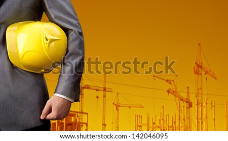 engineer yellow helmet for workers security over building crane on sunset sky