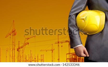 engineer yellow helmet for workers security over building crane on sunset sky Space for inscription