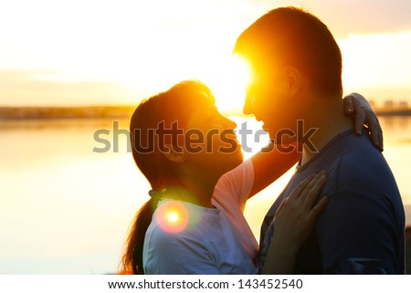 Happy couple riding bicycles outside, healthy lifestyle fun concept. silhouette at sunset panoramic night neon city bokeh background   copy Space for inscription
