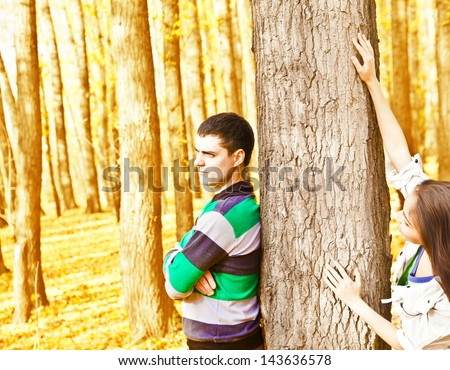 Young latin hispanic couple behind a tree an autumn symbol of quarrels misunderstandings depression divorce and separation hurt parting copy Space for inscription