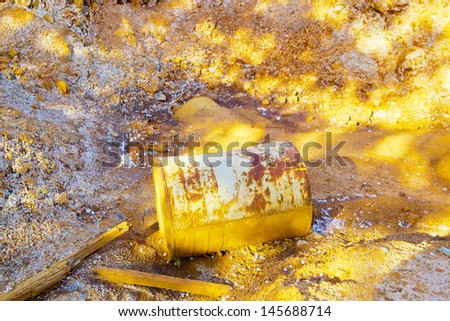 Rusty barrel and trash in the yellow or orange desert