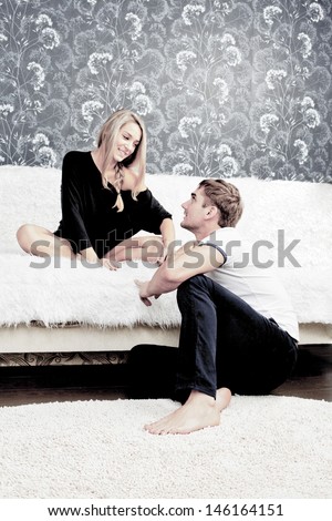 portrait of adult caucasian couple sitting on white sofa and floor at their apartment and planning renovation of their new apartment Copy space for inscription