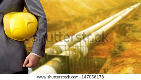 engineer yellow helmet for workers security against the background of the pit dug in the ground with new water pipes