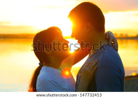 Young couple silhouette hugging and looking at each other outdoors at sunset background Copy space for inscription