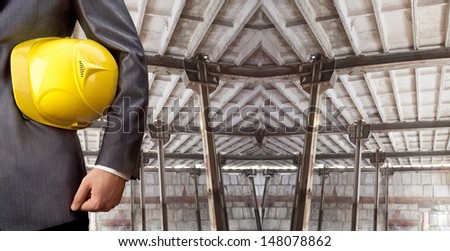 engineer yellow helmet for workers security against the support beams of the unfinished industrial workshop or room inside Copy space for inscription Horizontal
