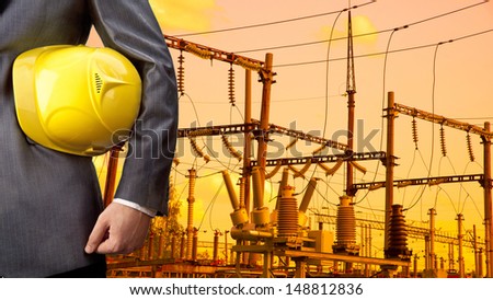 engineer yellow helmet for workers security against the background of the step-up or step-down transformer station in the sunset light Copy space for inscription