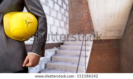 engineer yellow helmet for workers security against the background of the interior with the raise and lower the stairs in a building under construction Copy space for inscription