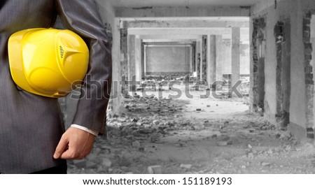 engineer yellow helmet for workers security over empty old building inside warehouse background Copy Space for inscription