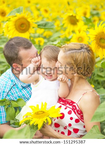 Copy space for inscription  Happy family - mom dad and daughter in autumn  field of beautiful sunflowers