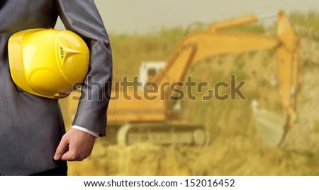 engineer yellow helmet for workers security over yellow excavator or digger  with bucket Copy space for inscription