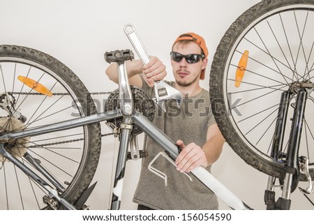 Mechanic or serviceman installing wheel on a bicycle in workshop
