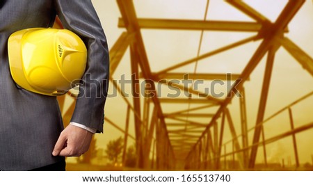 engineer yellow helmet for workers security against the support beams of the unfinished industrial bridge or room inside Copy space for inscription Horizontal