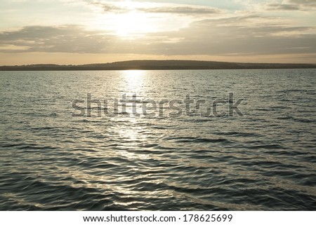 orange or yellow mystic blue Sea Sun rays set Background beautiful beach during sunset with fast moving dramatic clouds