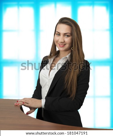 Portrait of young adult caucasian attractive female white collar worker in office on blue glass window background Copy space for inscription