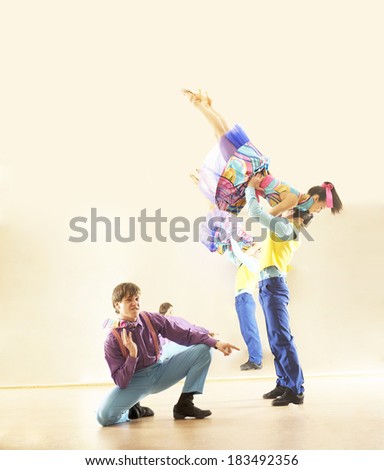 Portrait of three Happy teenage retro rock band on in very colorful dress on mirror reflection on wall background Two man and one woman full length looking at camera