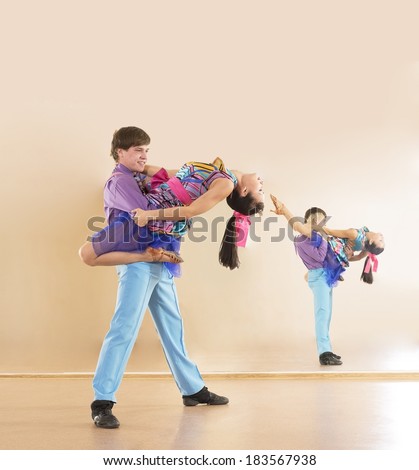 Portrait of two Happy teenage retro dance band on in very colorful dress on mirror reflection on wall background Couple man and one woman full length looking at each other