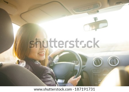 woman in car indoor keeps wheel turning around smiling looking at passengers in back seat idea taxi driver talking to police companion companion who asks for directions right to drive and Documents