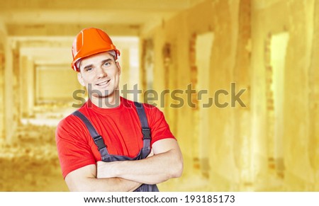 Portrait of smiley face engineer or hand worker wearing orange helmet for workers security and overall on yellow background of perspective doors inside old apartment buildings